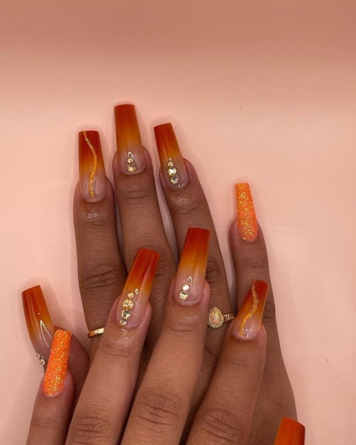 burnt orange nails with glitter and rhinestones 